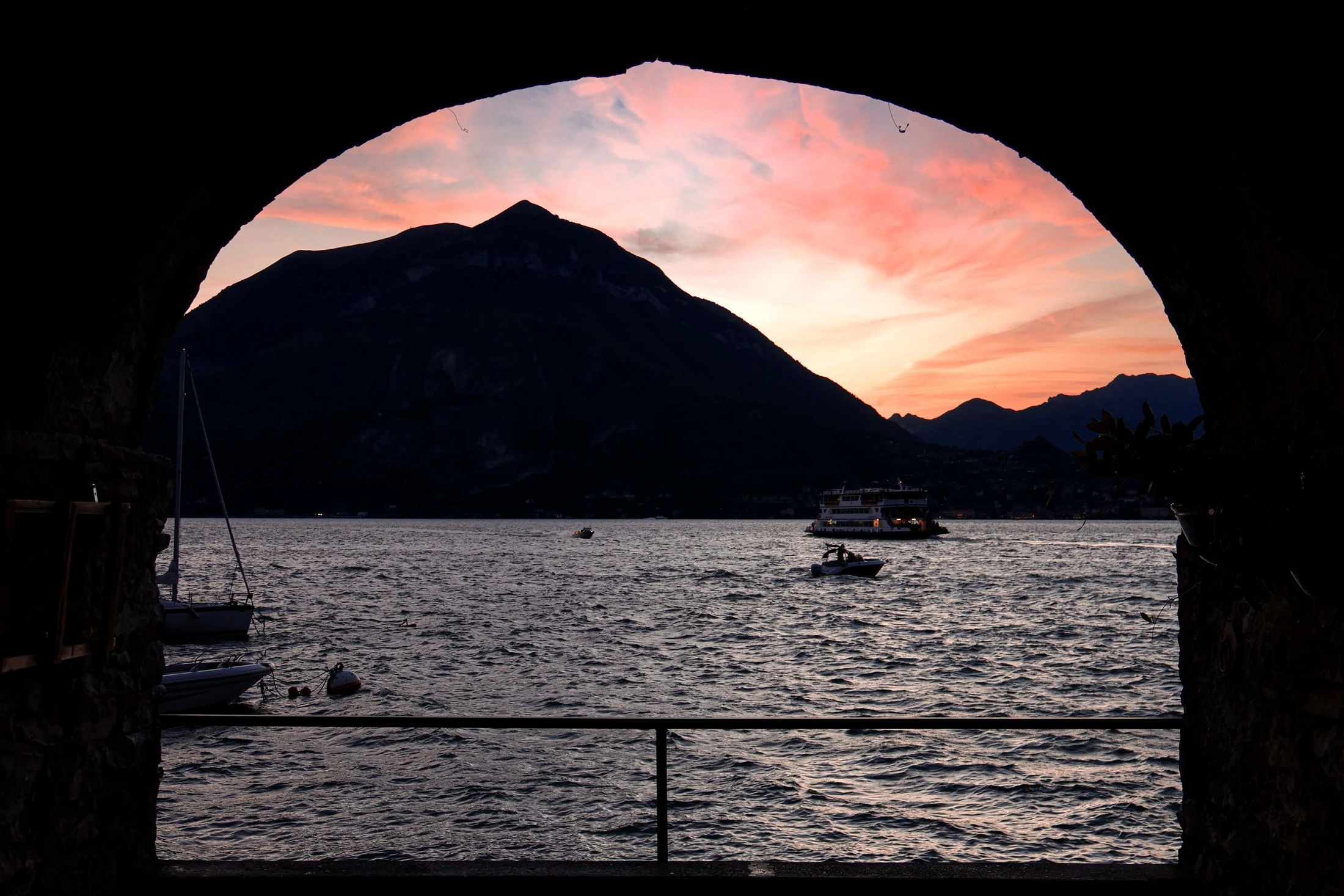 Abendhimmel über dem Comer See, eingerahmt von einem Steinbogen