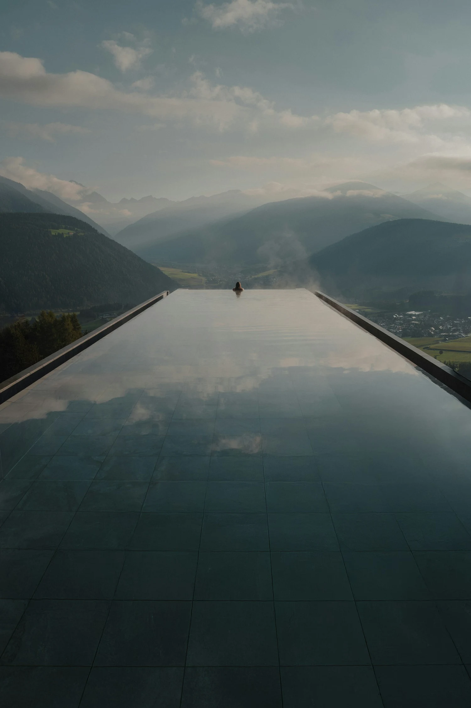 Infinitypool und alpine Bergketten im weichen Abendlicht